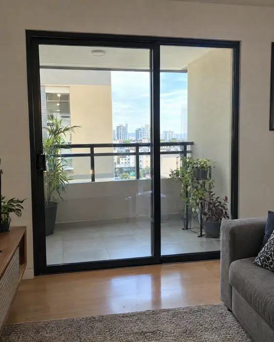 Porta de correr de vidro temperado entre a sala e a varanda